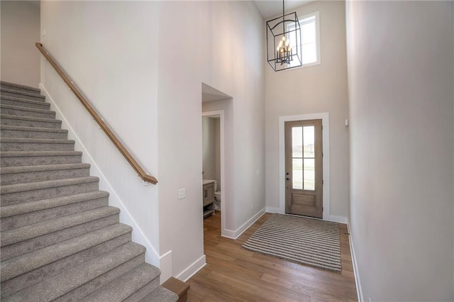 entryway featuring a towering ceiling, a chandelier, and hardwood / wood-style flooring