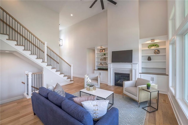 living room featuring a towering ceiling and light wood-type flooring