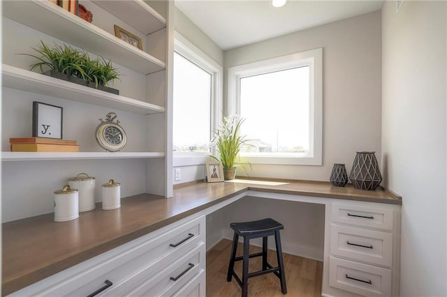 office space featuring built in desk and light hardwood / wood-style floors