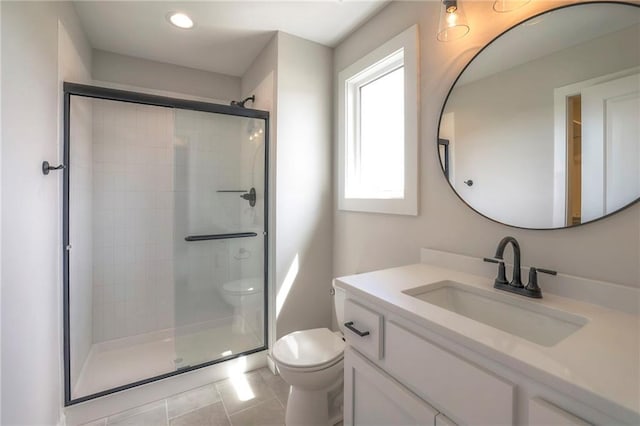 bathroom featuring tile patterned floors, vanity, toilet, and a shower with shower door