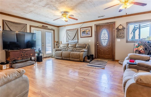 living room with ornamental molding, ceiling fan, french doors, and light hardwood / wood-style flooring