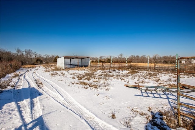 yard layered in snow with an outbuilding