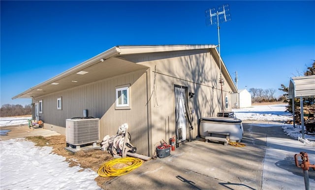 view of snow covered exterior with central AC