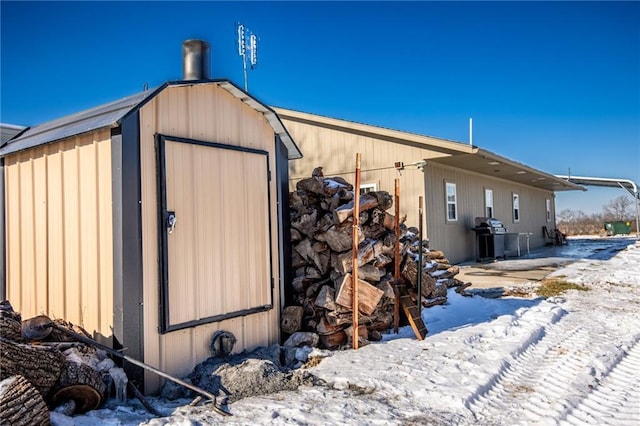 snow covered property with an outdoor structure