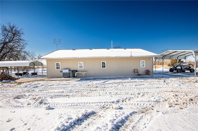 snow covered house with a carport