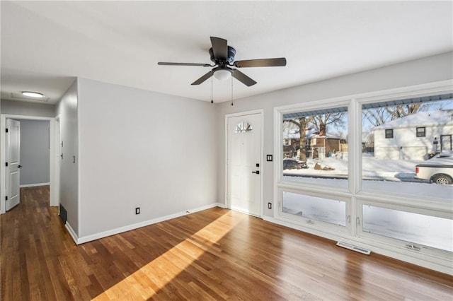 unfurnished room with ceiling fan and dark wood-type flooring