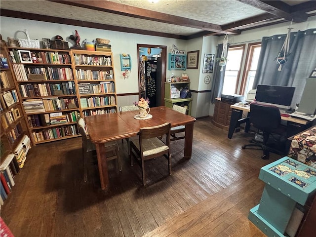 interior space featuring beamed ceiling, wood walls, dark wood-type flooring, and a textured ceiling