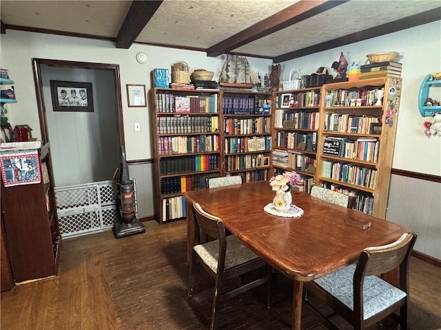 interior space featuring wood walls, beamed ceiling, dark wood-type flooring, and a textured ceiling