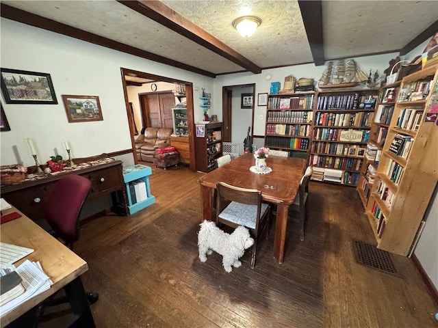 office featuring beamed ceiling, a textured ceiling, and dark wood-type flooring