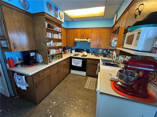 kitchen featuring a paneled ceiling, white appliances, and sink