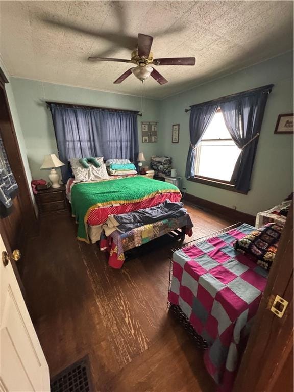 bedroom featuring ceiling fan, wood-type flooring, and a textured ceiling