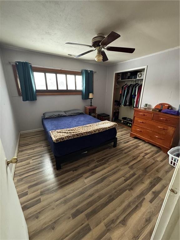 bedroom with dark hardwood / wood-style flooring, a closet, and ceiling fan