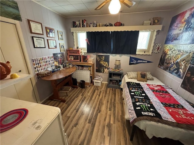 bedroom featuring hardwood / wood-style flooring, ceiling fan, and ornamental molding