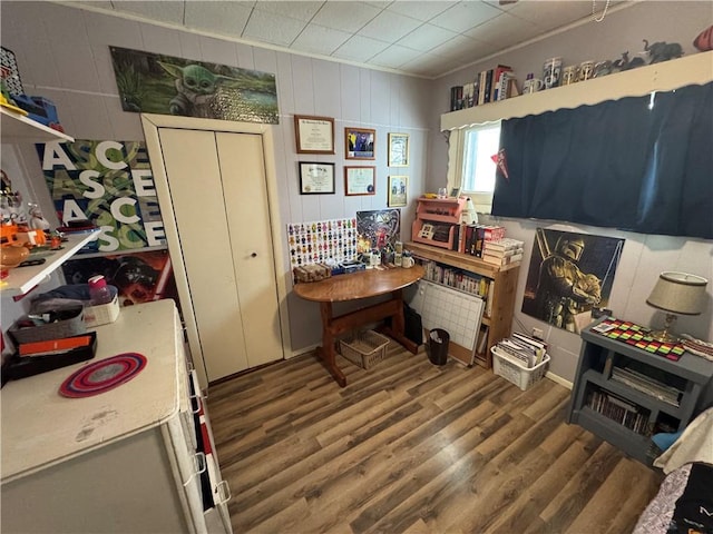 misc room featuring dark hardwood / wood-style flooring and wooden walls