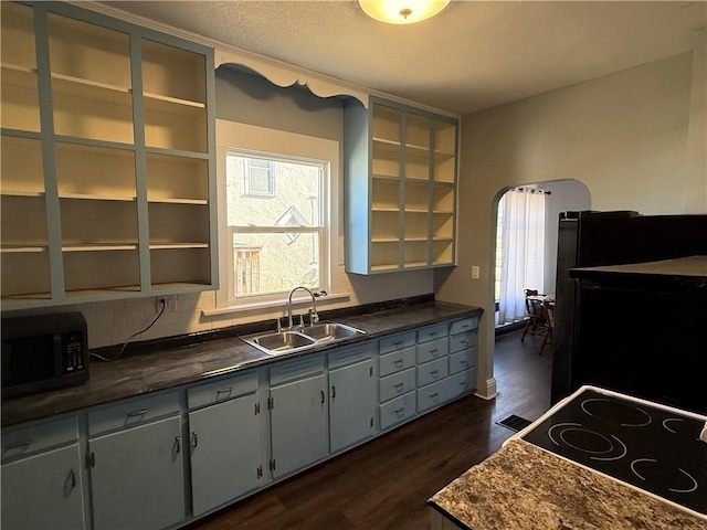 kitchen with refrigerator, stove, sink, and dark wood-type flooring