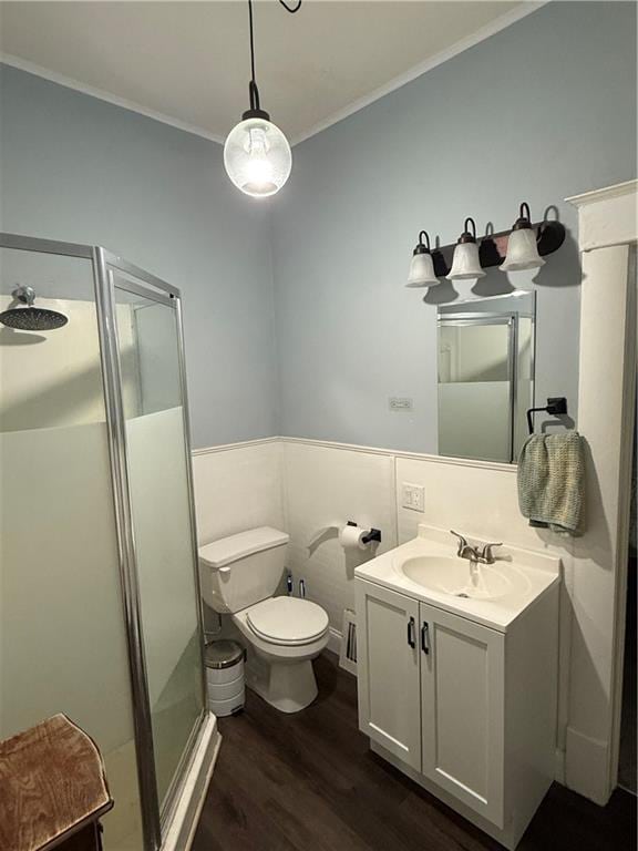 bathroom with ornamental molding, vanity, hardwood / wood-style flooring, toilet, and a shower with shower door