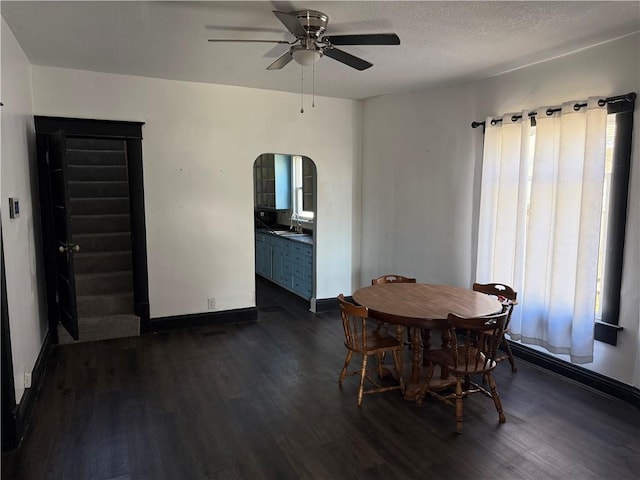 dining space with a textured ceiling, ceiling fan, dark hardwood / wood-style floors, and sink