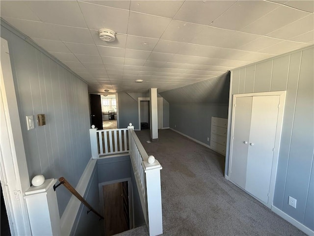 corridor with carpet flooring and vaulted ceiling