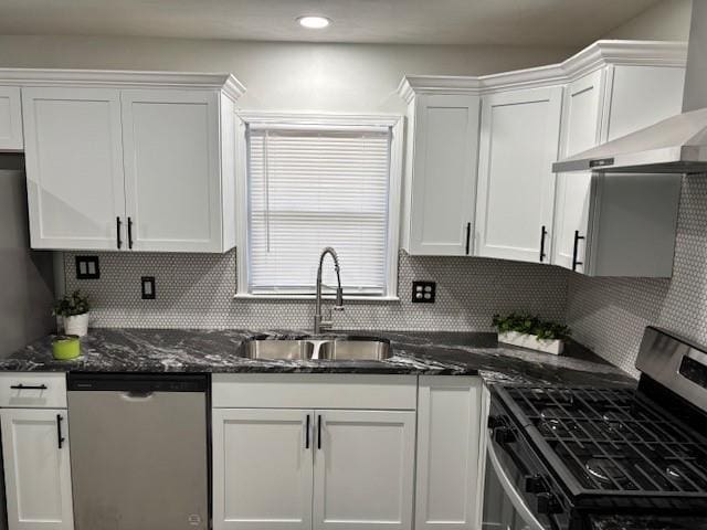 kitchen featuring white cabinetry, sink, wall chimney range hood, decorative backsplash, and appliances with stainless steel finishes