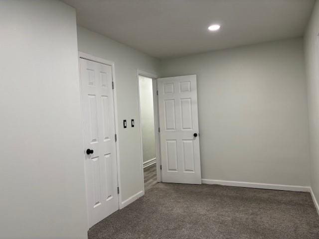 spare room with dark colored carpet