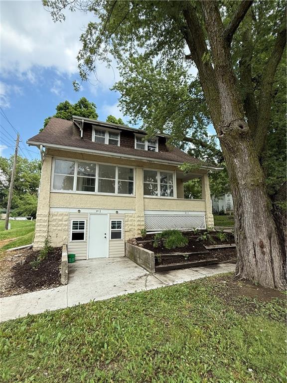 211 N Mulberry St, Maryville, MO 64468 - back of house with a lawn, a patio area, and a shingled roof