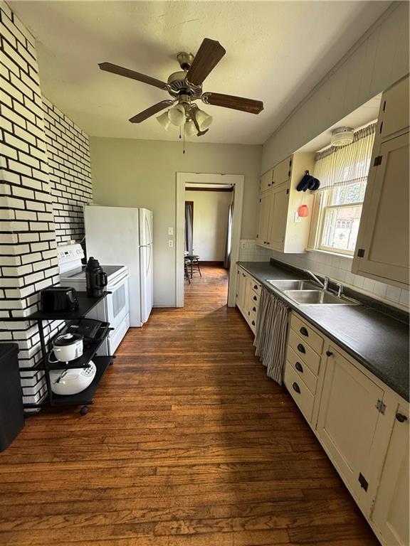 211 N Mulberry St, Maryville, MO 64468 - kitchen with white appliances, dark wood-style floors, backsplash, and dark countertops