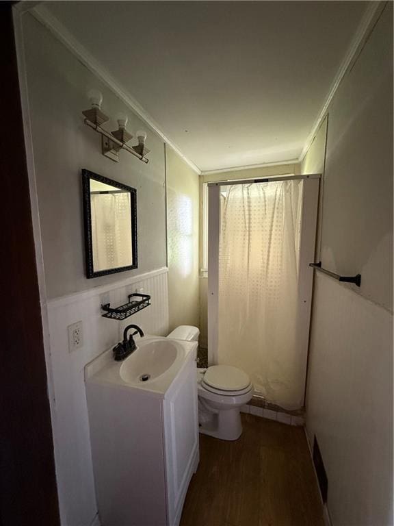 211 N Mulberry St, Maryville, MO 64468 - bathroom with wood finished floors, vanity, crown molding, a shower with shower curtain, and wainscoting