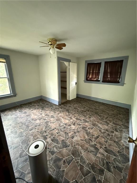 211 N Mulberry St, Maryville, MO 64468 - empty room with stone floors and a ceiling fan