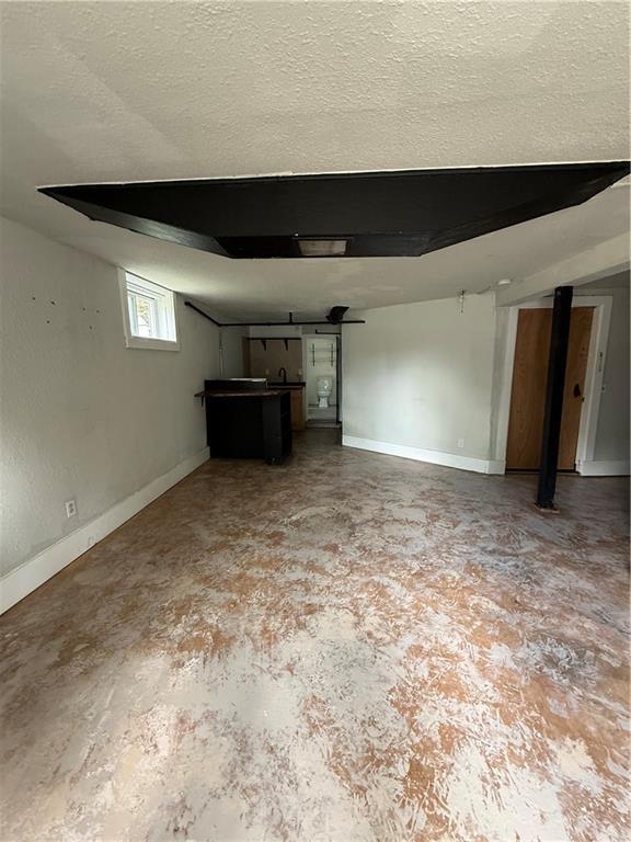 211 N Mulberry St, Maryville, MO 64468 - unfurnished living room with concrete flooring and a textured ceiling