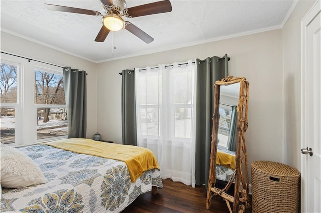 bedroom featuring ceiling fan, dark wood-type flooring, ornamental molding, and a textured ceiling