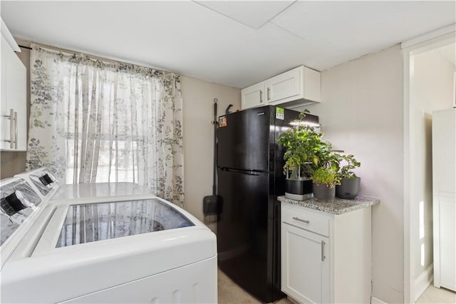 kitchen with black fridge and white cabinetry