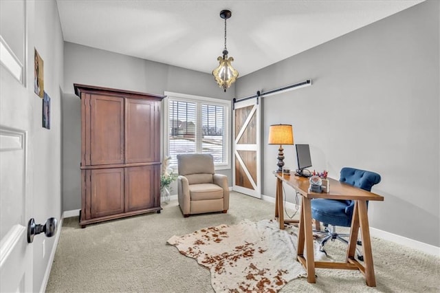 carpeted home office with a barn door