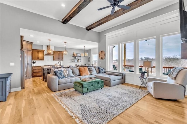 living room with ceiling fan, beam ceiling, and light wood-type flooring