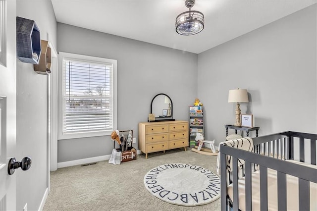 carpeted bedroom featuring a crib