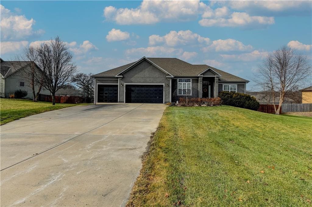 ranch-style house with a garage and a front lawn