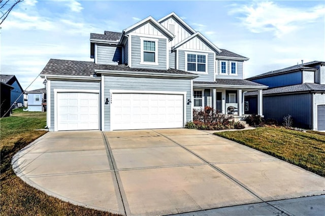 view of front of property with a garage, a front yard, and covered porch