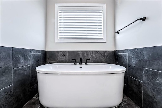 bathroom featuring a bathing tub and tile walls