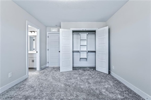 unfurnished bedroom featuring carpet floors, ensuite bath, and a closet