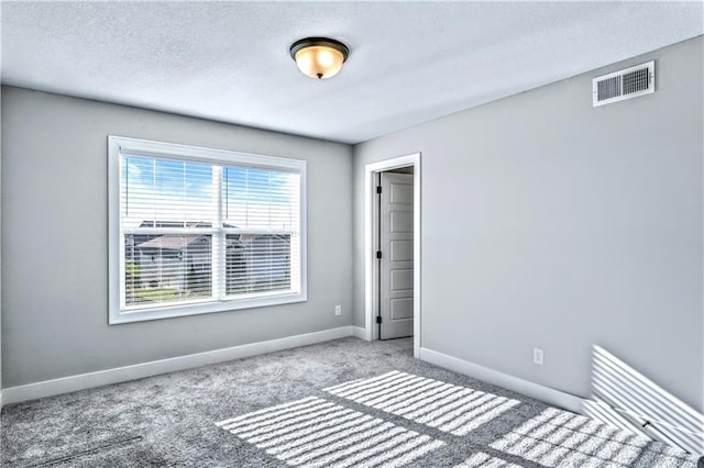 unfurnished bedroom featuring carpet and a textured ceiling