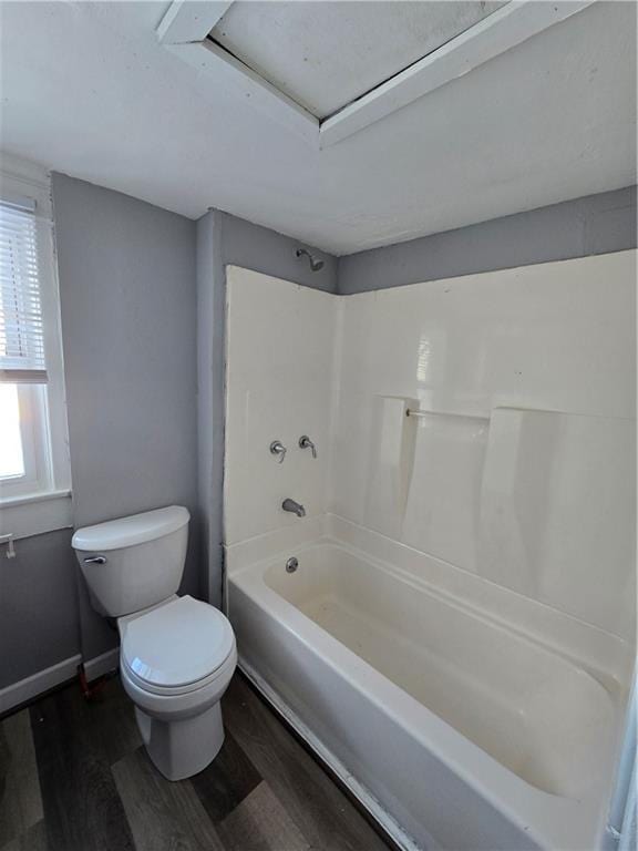 full bathroom featuring shower / bathtub combination, baseboards, toilet, and wood finished floors