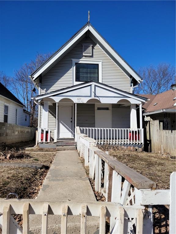 view of front of property with a porch and fence