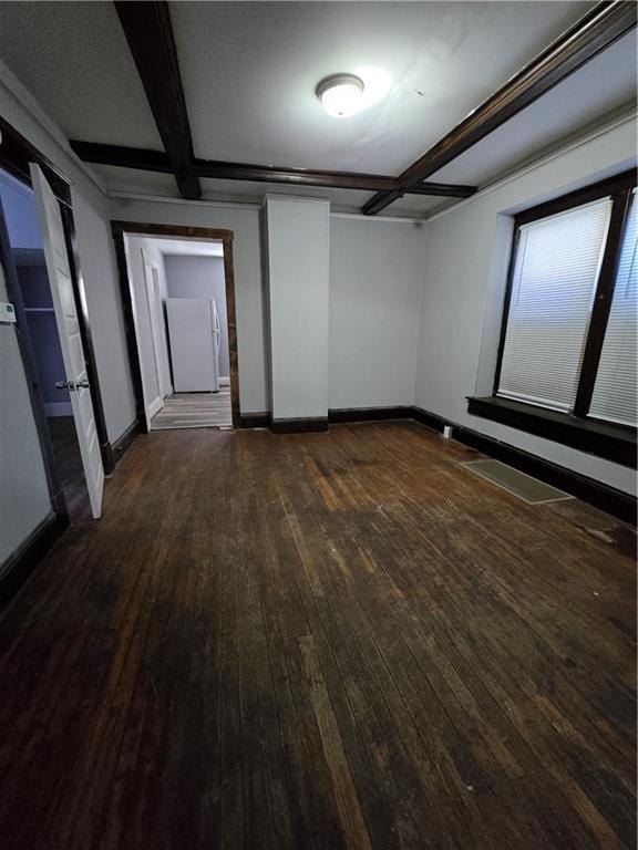 empty room with baseboards, dark wood finished floors, and beamed ceiling