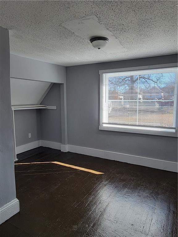 additional living space with a textured ceiling and baseboards