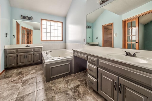 bathroom with vanity, a bathtub, and lofted ceiling