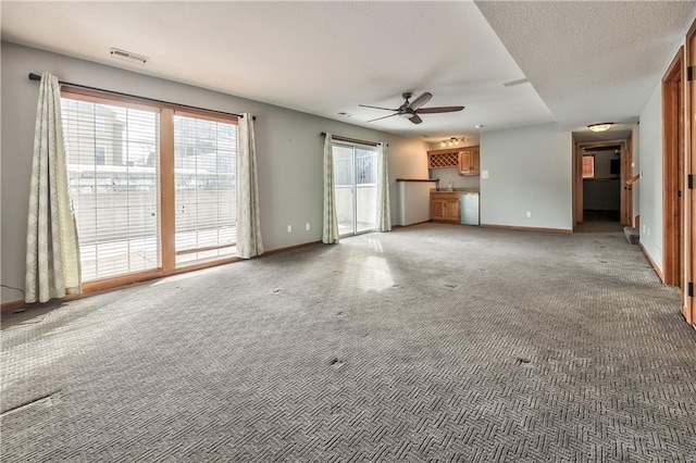 unfurnished living room with ceiling fan and carpet