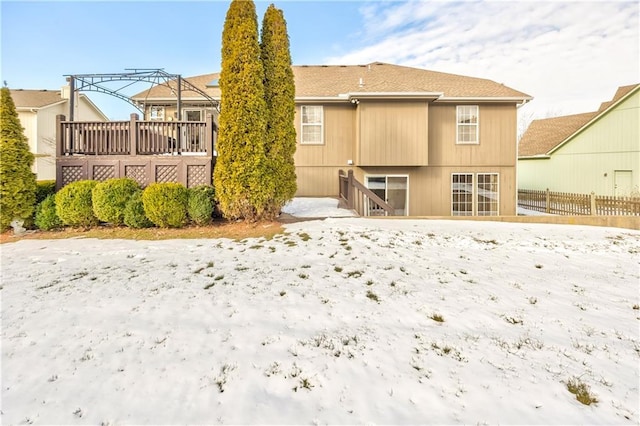 snow covered rear of property featuring a deck