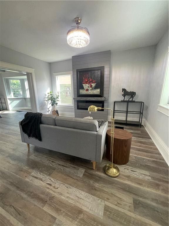 living room with a fireplace, a healthy amount of sunlight, and dark hardwood / wood-style floors