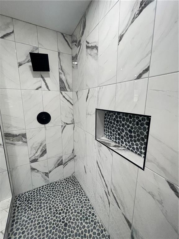 bathroom with a tile shower