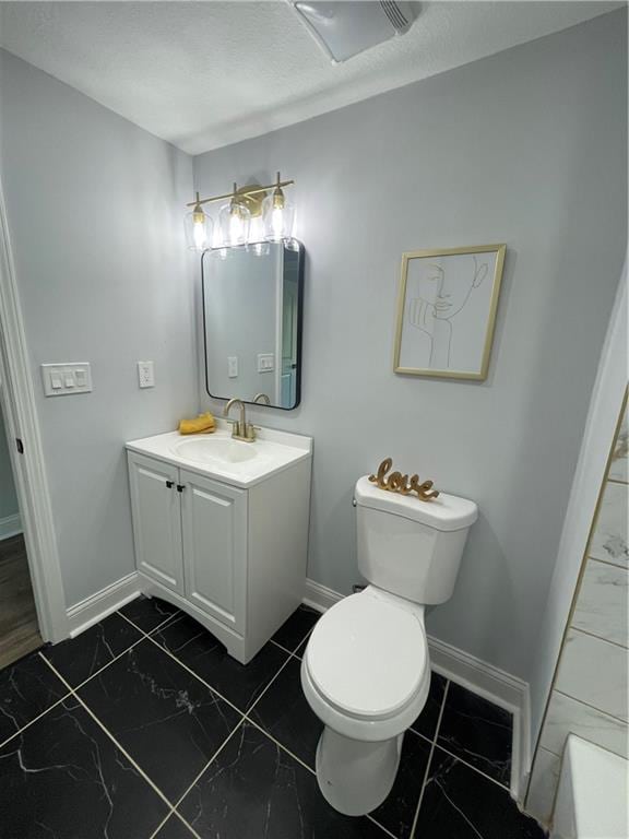 bathroom featuring a bathing tub, vanity, and toilet