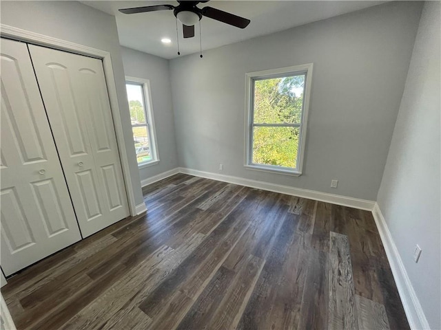 unfurnished bedroom featuring ceiling fan, dark hardwood / wood-style flooring, and a closet